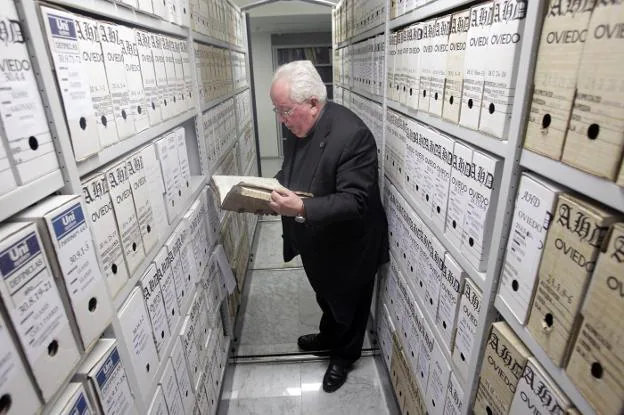 Agustín Hevia Ballina, en el sótano del Archivo Histórico Diocesano, entre los armarios mecanizados que custodian los libros. 