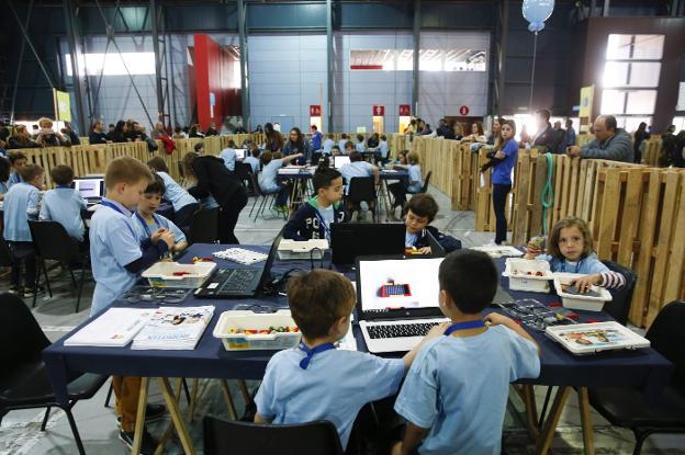 Varios equipos de alumnos, rodeados de piezas y ordenadores, trabajan en sus proyectos durante la primera jornada de la Robotix League 2018, que tuvo lugar ayer en el recinto ferial Luis Adaro. 