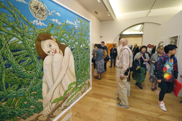 Visitantes y participantes en la inauguración observan los cuadros de la exposición 'Japón, línea y color', en el Antiguo Instituto. 
