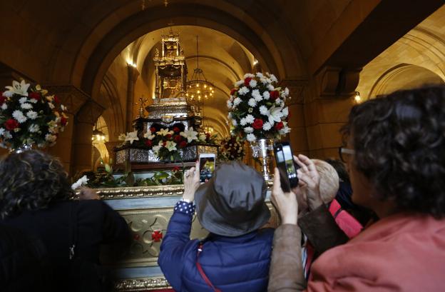 Feligreses fotografían la custodia de plata que este año no pudo sacarse en procesión por la lluvia. 