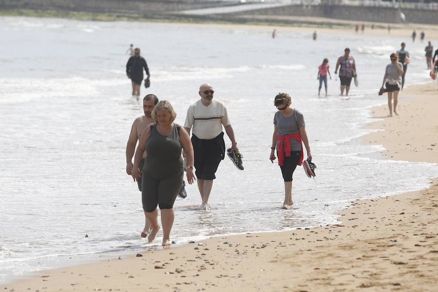 Tras dos días cerrada por vertidos, el Ayuntamiento de Gijón ha izado la bandera verde en la playa de San Lorenzo en un día de tiempo agradable que ha animado a numerosos vecinos y visitantes a acercarse al arenal.