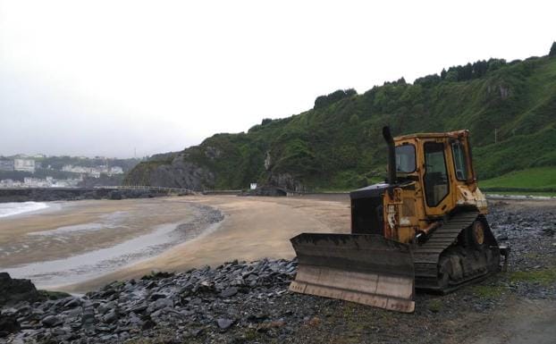 Luarca. Fue necesario utilizar maquinaria pararetirar piedras arrastradas hasta la arena. 