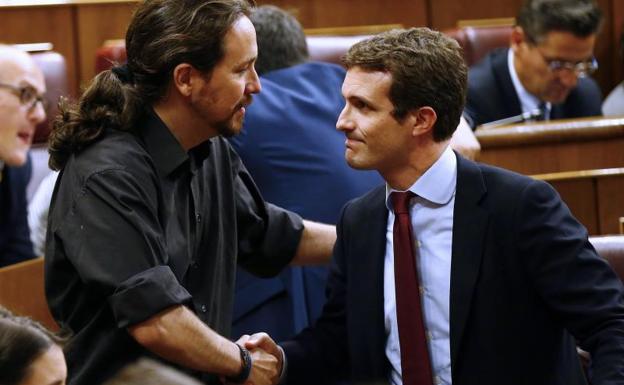 El secretario general de Podemos, Pablo Iglesias, saluda al vicesecretario general de Comunicación del PP, Pablo Casado.