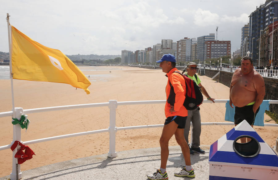 Las banderas amarilla y verde que luce la playa y la buena temperatura ya ha animado a algunas personas a pegarse un baño en el Cantábrico. 