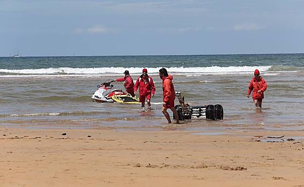 Los socorristas, dentro del agua de la playa de San Lorenzo. 