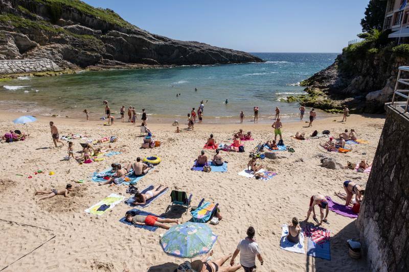 Miles de personas disfrutan del primer fin de semana del verano en las playas de Asturias. Arenales como San Lorenzo, en Gijón, o Rodiles, en Villaviciosa, están a rebosar. 