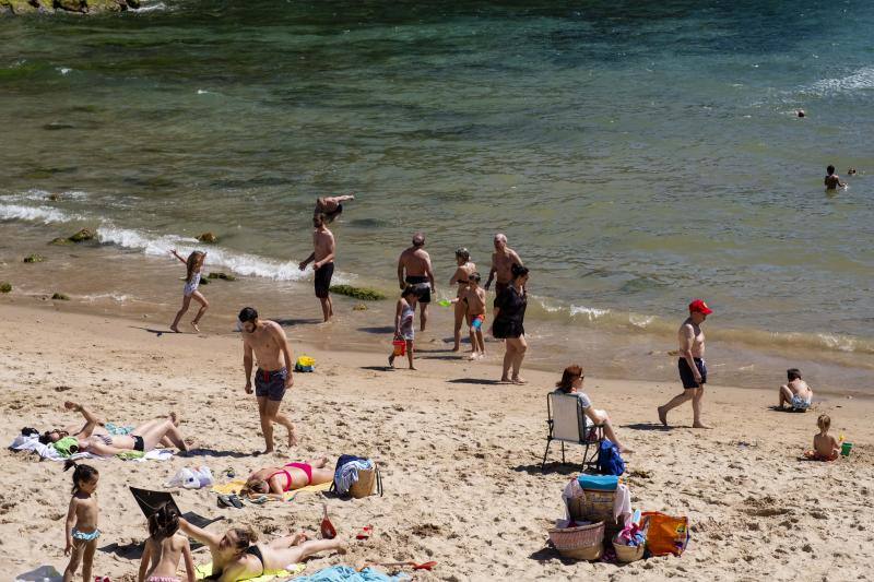 Miles de personas disfrutan del primer fin de semana del verano en las playas de Asturias. Arenales como San Lorenzo, en Gijón, o Rodiles, en Villaviciosa, están a rebosar. 