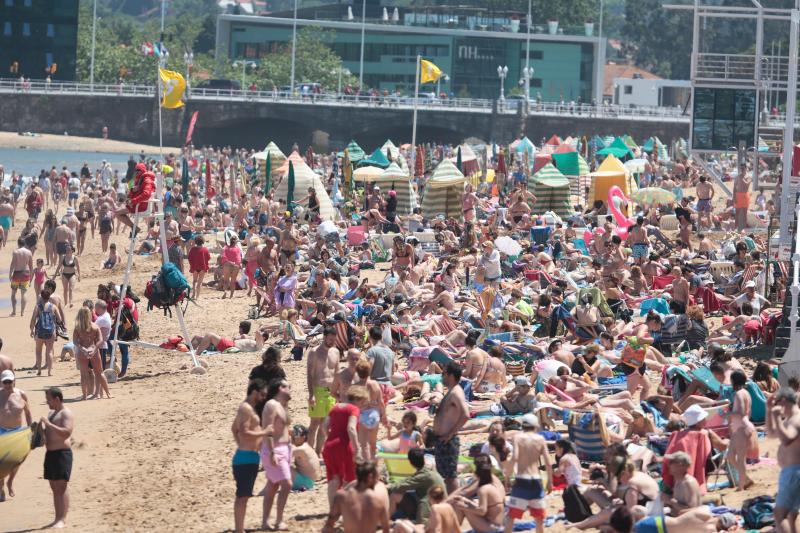 Miles de personas disfrutan del primer fin de semana del verano en las playas de Asturias. Arenales como San Lorenzo, en Gijón, o Rodiles, en Villaviciosa, están a rebosar. 