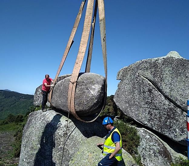 Los operarios colocan el penedo cuidando la oscilación y la seguridad del conjunto. 