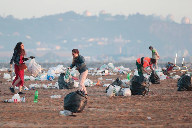 La fiesta de San Juan ha dejado toneladas de basura en la playa de Poniente. Desde antes del amanecer, operarios de Emulsa trabajan en la recogida de los residuos para dejar listo el arenal para un nuevo día de pleno verano.