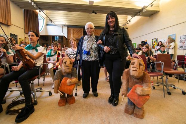 Irene Sierra y Eva Tejedor posan con las esculturas del Premio de Percusión Tradicional Manegueru de Nava. 