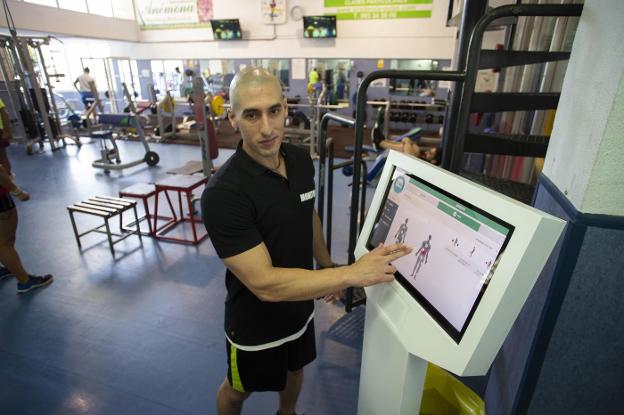 Miguel Álvarez, junto a la nueva máquina de rutinas de entrenamientos, en el gimnasio. 