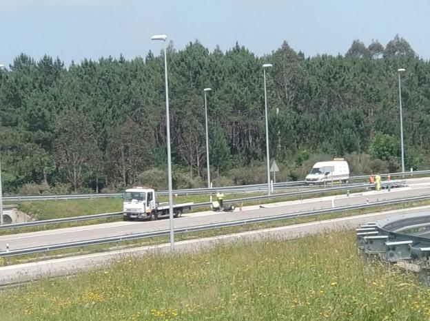 Agentes de la Guardia Civil de Tráfico de Luarca realizan mediciones en el lugar del accidente, en la salida 495 de la A-8, en Tapia. 