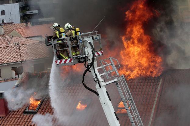 Los dos bomberos, durante las labores de extinción del incendio de Uría. 