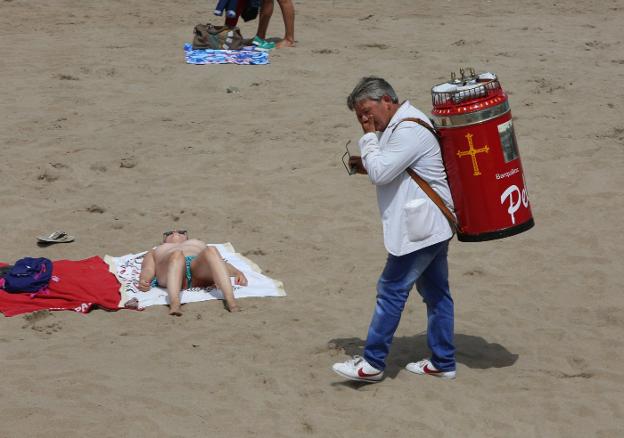 Un barquillero se seca el sudor en la playa de Salinas. 