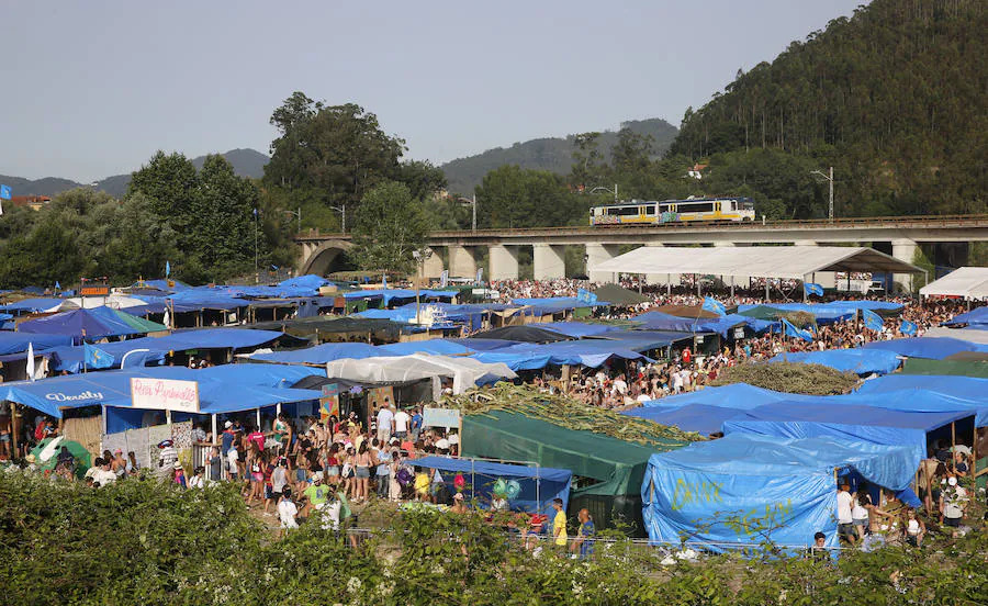 Miles de personas disfrutan de la popular fiesta del Xiringüelu en el prau Salcéu de Pravia en una jornada marcada por el sol y el intenso calor. 