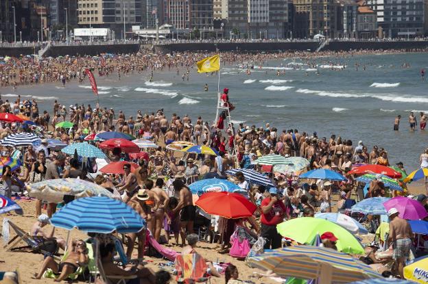 La playa de San Lorenzo, repleta de bañistas, en una jornada en la que en la ciudad se alcanzaron los 28,7 grados. 