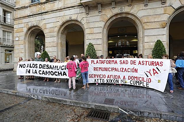 Los vecinos de La Camocha y las trabajadoras de ayuda a domicilio, protestando en la plaza Mayor. 