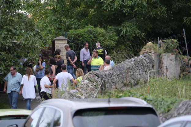 Los hijos y la mujer de Ardines, junto a vecinos, amigos e investigadores, en la entrada del camino donde fue encontrado el cuerpo el jueves por la mañana. 