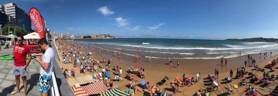 El sol y el calor anunciados para este fin desemana han llenado las playas de Asturias. En San Lorenzo, por ejemplo, miles de personas disfrutan del arenal y del paseo del Muro.