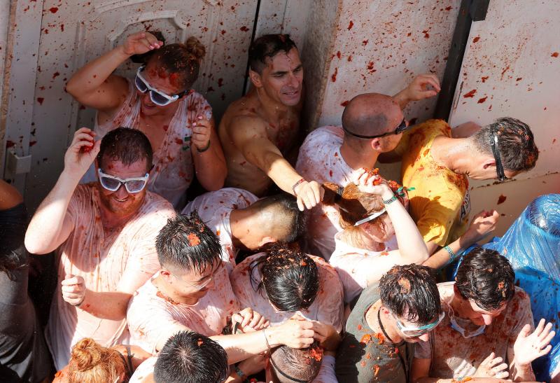 La localidad valenciana de Buñol se ha teñido de fiesta en la popular Tomatina, que ha congregado a unas 20.000 personas han lanzado unos 145.000 kilos de tomate repartidos en siete camiones, cifras que confirman que es una de las grandes citas festivas del verano en España. 