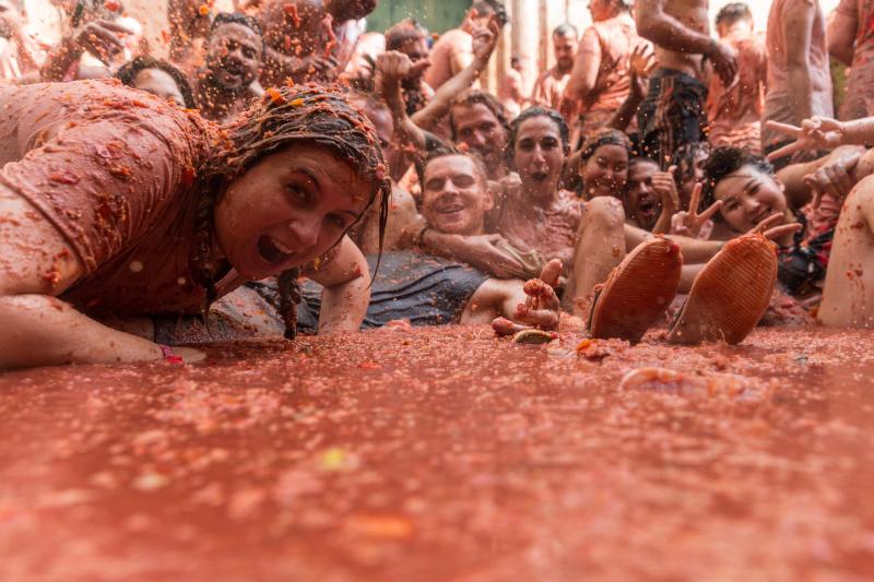 La localidad valenciana de Buñol se ha teñido de fiesta en la popular Tomatina, que ha congregado a unas 20.000 personas han lanzado unos 145.000 kilos de tomate repartidos en siete camiones, cifras que confirman que es una de las grandes citas festivas del verano en España. 