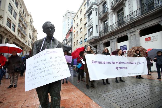 La estatua de Woody Allen en Oviedo, con un cartel de denuncia. 