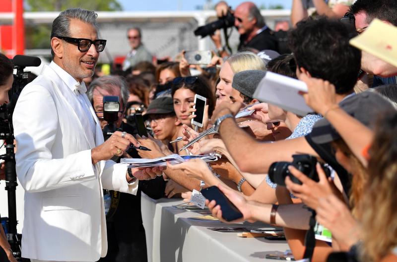 El actor estadounidense Jeff Goldblum (i) firma autógrafos a sus seguidores a su llegada a la proyección de la cinta ''La montaña'' durante el 75º Festival Internacional de Cine de Venecia.