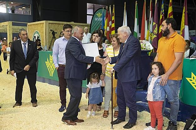 El homenajeado Carlos Méndez recibe una placa conmemorativa acompañado de su esposa Rosa, hijos y nietos.