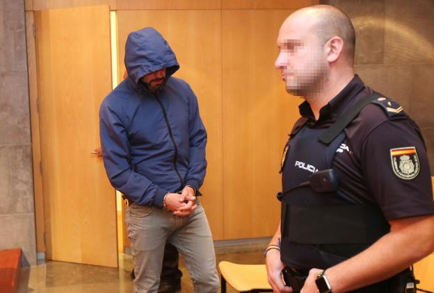 El condenado con capucha y escoltado por la Policía durante la vista en el Penal 2 de Oviedo. 