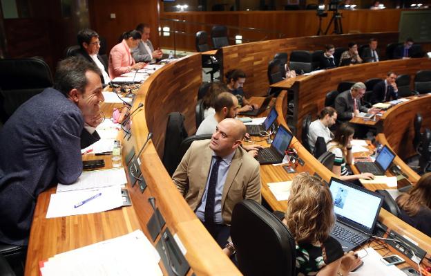 El diputado Ovidio Zapico (IU), hablando con Pedro Leal (Foro). Al fondo los escaños de Ciudadanos, Podemos y el PP. 