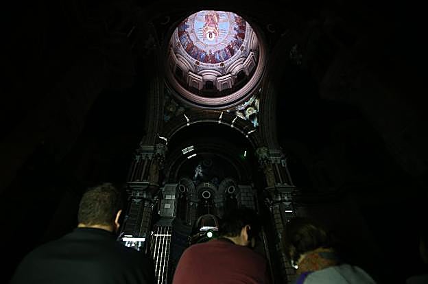La cúpula de la basílica de San Juan el Real iluminada por la acción de los punteros láser ante la mirada del público asistente. 
