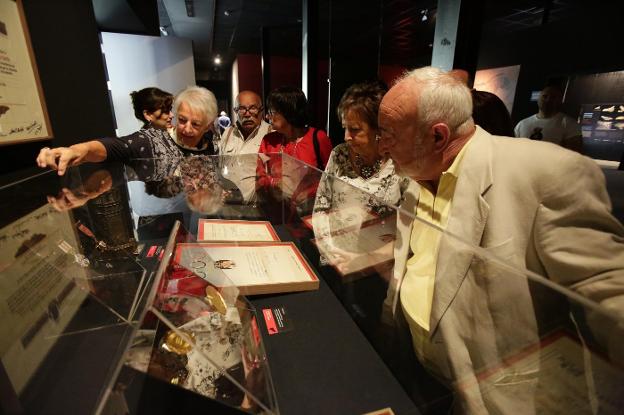 Eloisa Fernández Bustillo señala las distinciones de su hermano ante Adolfo Inda, Amparo Izquierdo, Juliana Díaz y Ruperto Álvarez, con la Medalla de Oro de Asturias en primer término, en el Centro de Arte Rupestre de Tito Bustillo. 