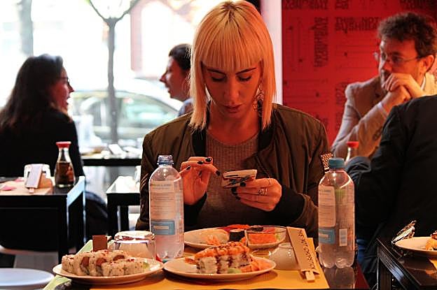 Una chica comparte su plato de sushi en el restaurante milanés. 