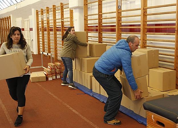 Los voluntarios trasladan los alimentos a la Cocina Económica. 