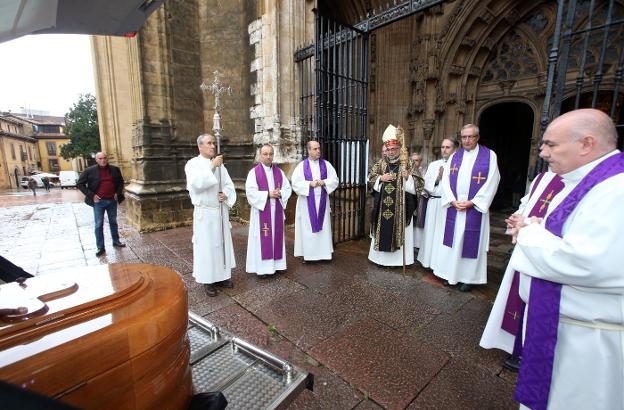 El arzobispo y resto de curas delante del féretro. 