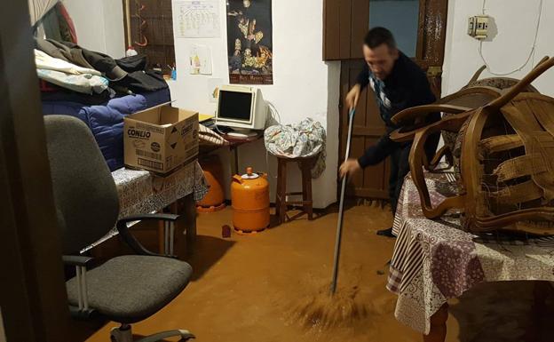 Un vecino de Bobadilla Estación trata de achicar agua en su vivienda. 