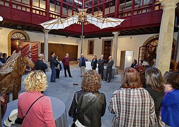 En el centro, bajo las alas batientes de Leonardo, Alberto Peña, en el centro, explica a autoridades e invitados a la inauguración los pormenores de la muestra . 