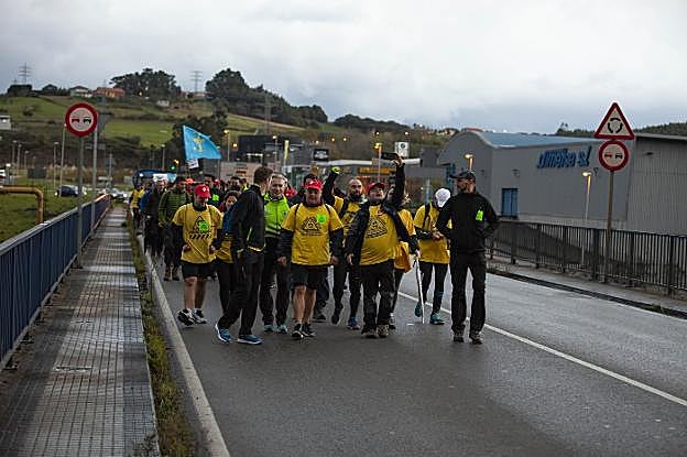 Los participantes en la marcha pasan por la zona industrial de Avilés en dirección hacia Llaranes, poco después de iniciar su camino hacia Oviedo. 