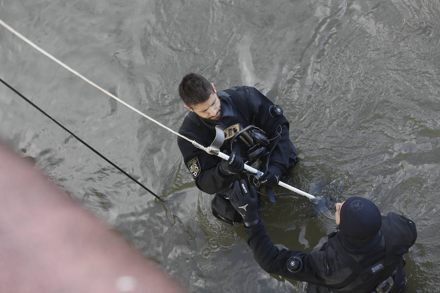 Buzos de la Policía, provistos de un detector de metales, han continuado con las labores de rastreo en el río Nalón para dar con el arma que acabó con la vida del joven de La Felguera Iván Castro. El hermano de la víctima ha seguido los trabajos