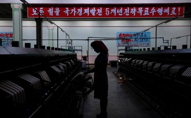 Fotografía de archivo que muestra la silueta de una empleada norcoreana en una fábrica de seda en Pyongyang.