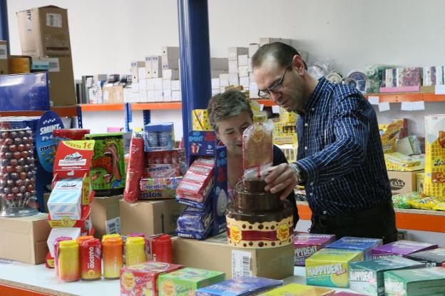 Dos clientes observan los productos de la Feria de la Golosina en Asturarco. 