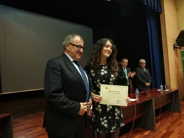 El alcalde de Valdés, Simón Guardado, entrega la beca Severo Ochoa a Andrea Pérez. 