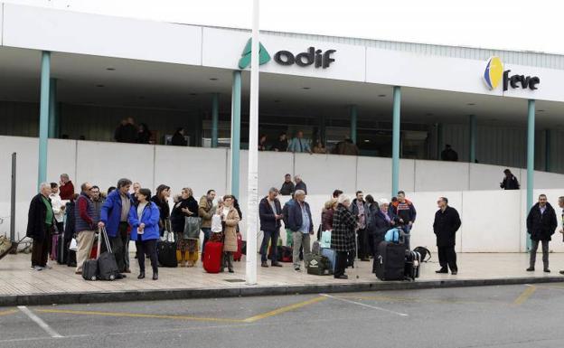 Un grupo de pasajeros esperan en la estación de tren de Gijón el autobús que les llevará a León