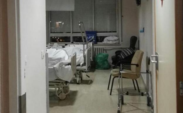 Una de las habitaciones triples, en la cuarta planta del Hospital de Cabueñes. La falta de armario para la tercera paciente obligó a dejar sus efectos personales en una bolsa de plástico en el suelo. 