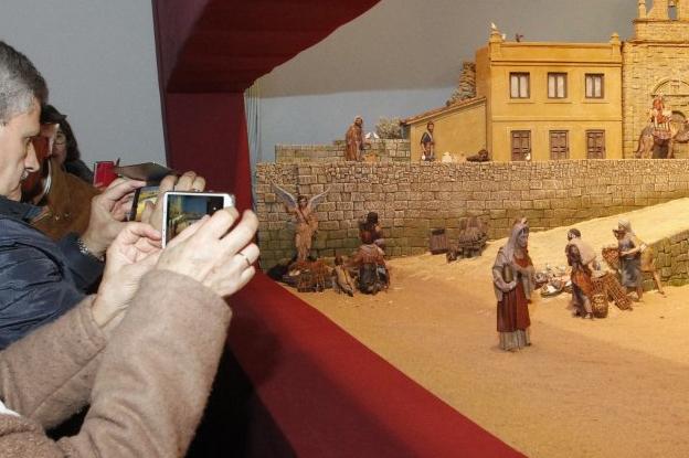 Varios ciudadanos fotografían con sus teléfonos móviles el belén dedicado a Jovellanos, en el Antiguo Instituto. 
