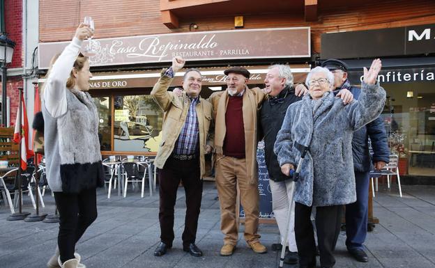 Varios afortunados celebran un premio de la Lotería de Navidad. 