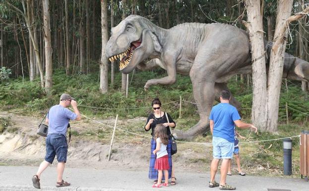 Turistas junto a uno de los dinosaurios del Muja.