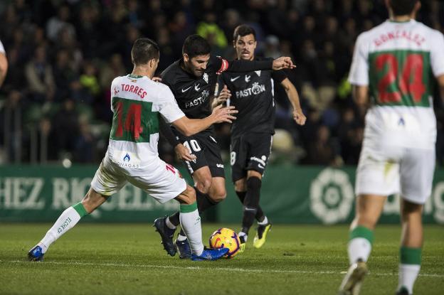 Xavi Torres intente arrebatar el balón a Carmona, ante la mirada de Geraldes. 