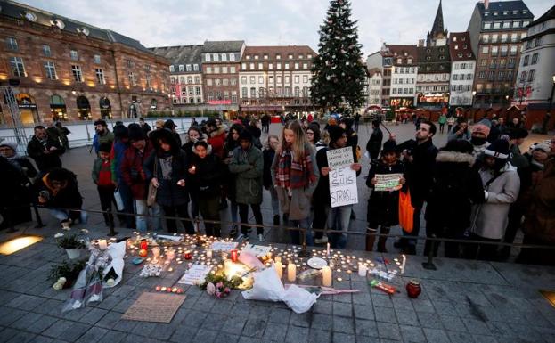 Ciudadanos encienden velas y escriben mensajes en el lugar donde falleció una de las víctimas de Estrasburgo.
